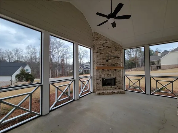 a view of an empty room with chandelier fan and a floor to ceiling window