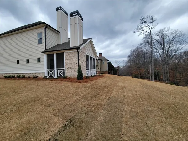a front view of a house with large trees