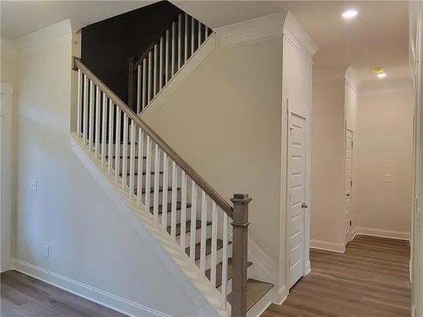 a view of staircase with wooden floor and white walls