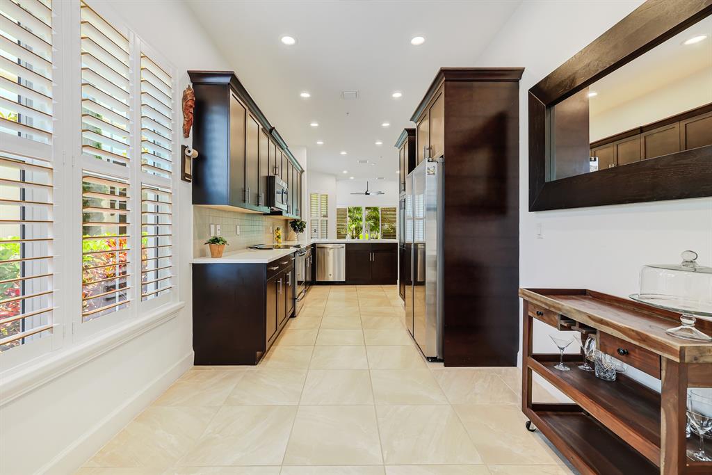 22954 Clear Echo Drive, Unit 31 Boca Raton, FL 33433 - Photo 11 of 44 a kitchen with stainless steel appliances kitchen island granite countertop a refrigerator and a stove top oven