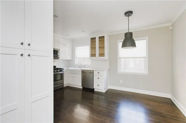 a kitchen with granite countertop white cabinets and white appliances