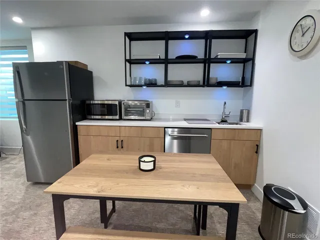 a kitchen with a table chairs refrigerator and microwave