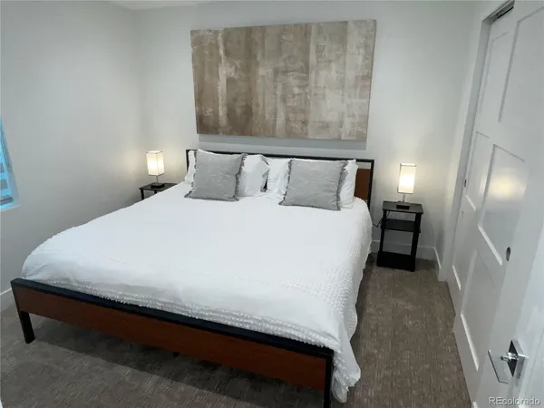 a large bed sitting in a bedroom next to a lamp