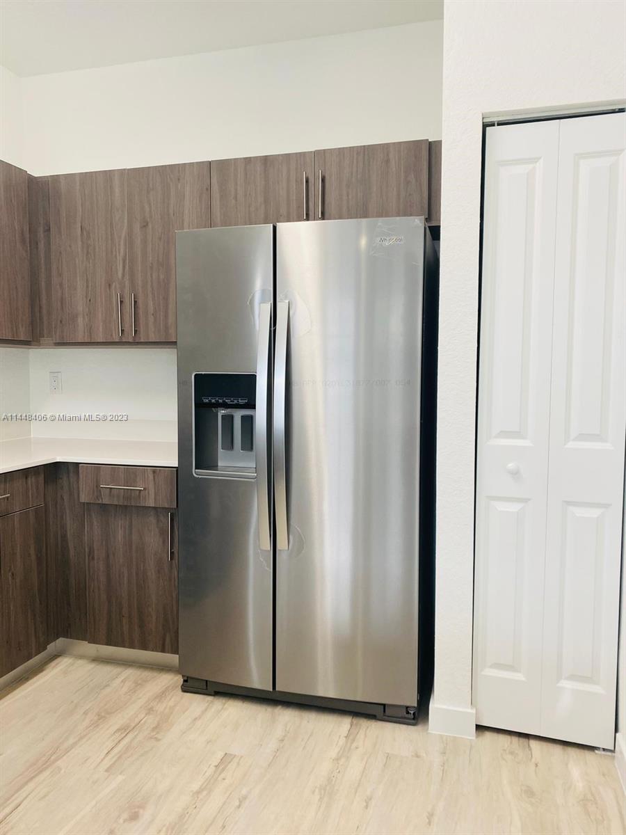 15520 Southwest 136th Street, Unit 106 Miami, FL 33196 - Photo 5 of 11 a view of a kitchen with wooden cabinets