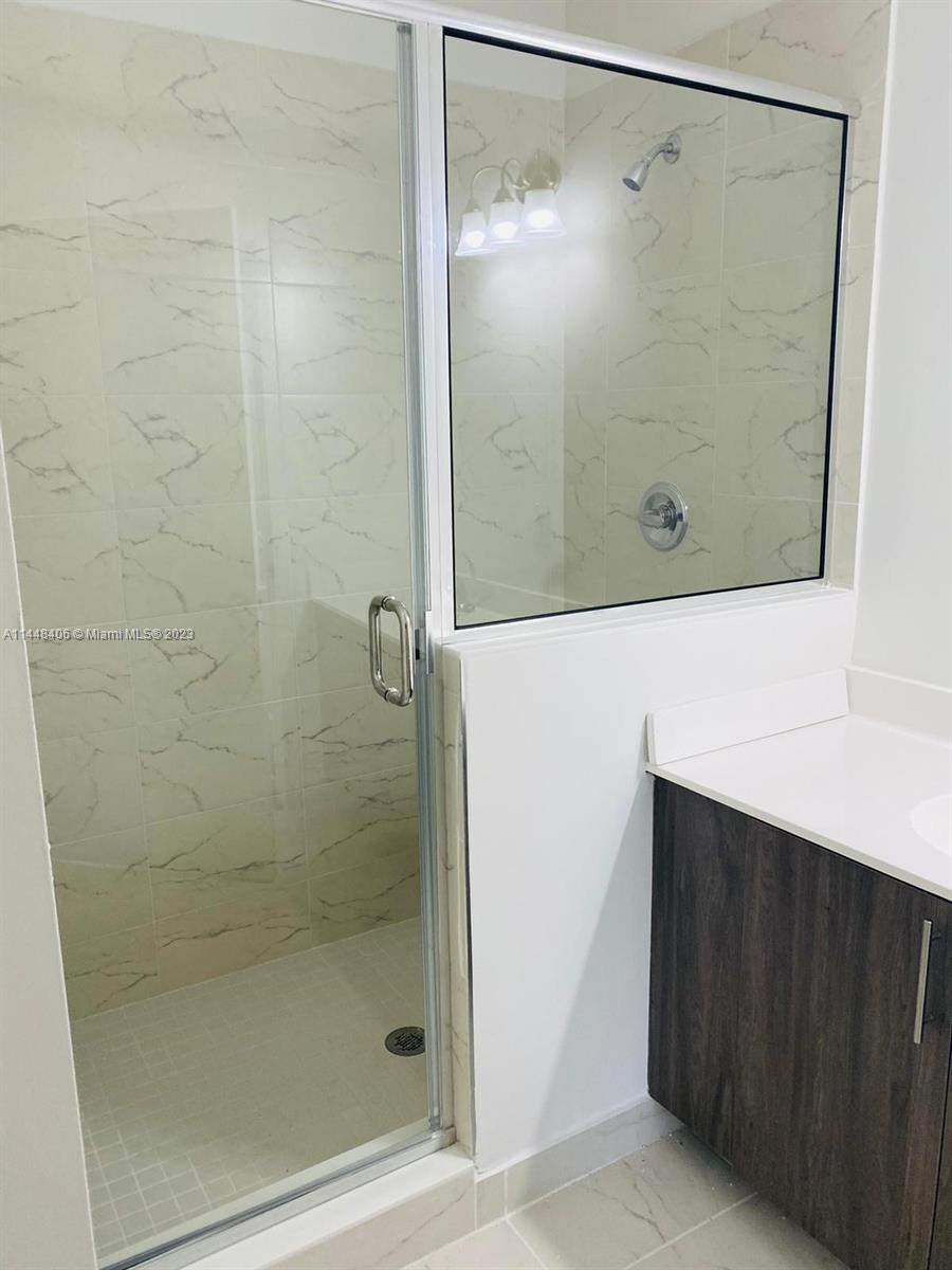 15520 Southwest 136th Street, Unit 106 Miami, FL 33196 - Photo 8 of 11 a bathroom with a shower and a mirror