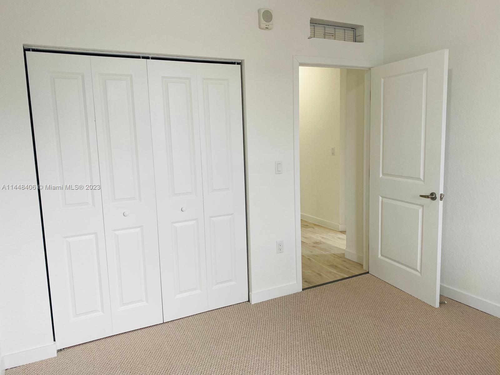 15520 Southwest 136th Street, Unit 106 Miami, FL 33196 - Photo 10 of 11 an empty room with a wooden door
