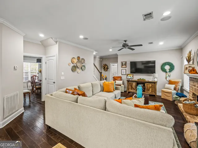 a living room with furniture kitchen view and a flat screen tv