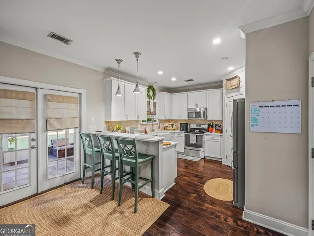 a kitchen with a table chairs refrigerator and cabinets