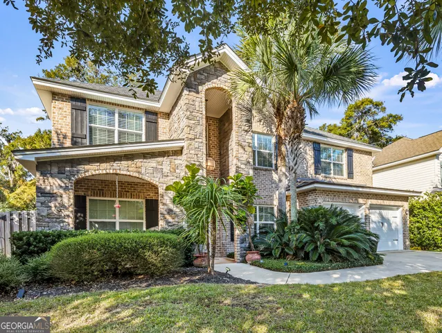 a front view of a house with plants and entryway