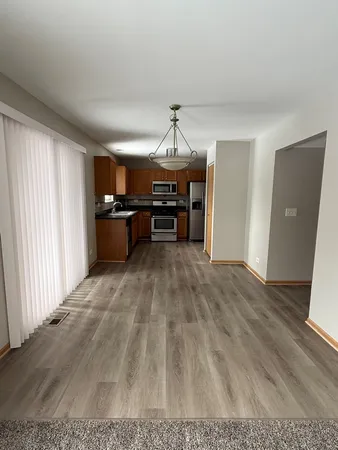a view of a living room a kitchen with a sink cabinets and wooden floor
