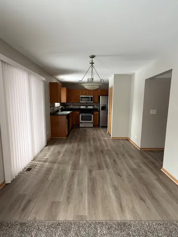 a view of a living room a kitchen with a sink cabinets and wooden floor