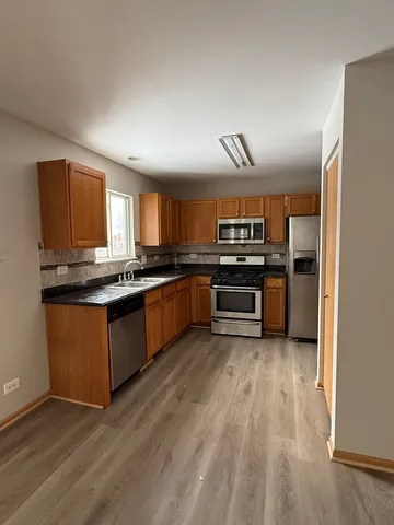 a kitchen with stainless steel appliances granite countertop a stove cabinets and refrigerator