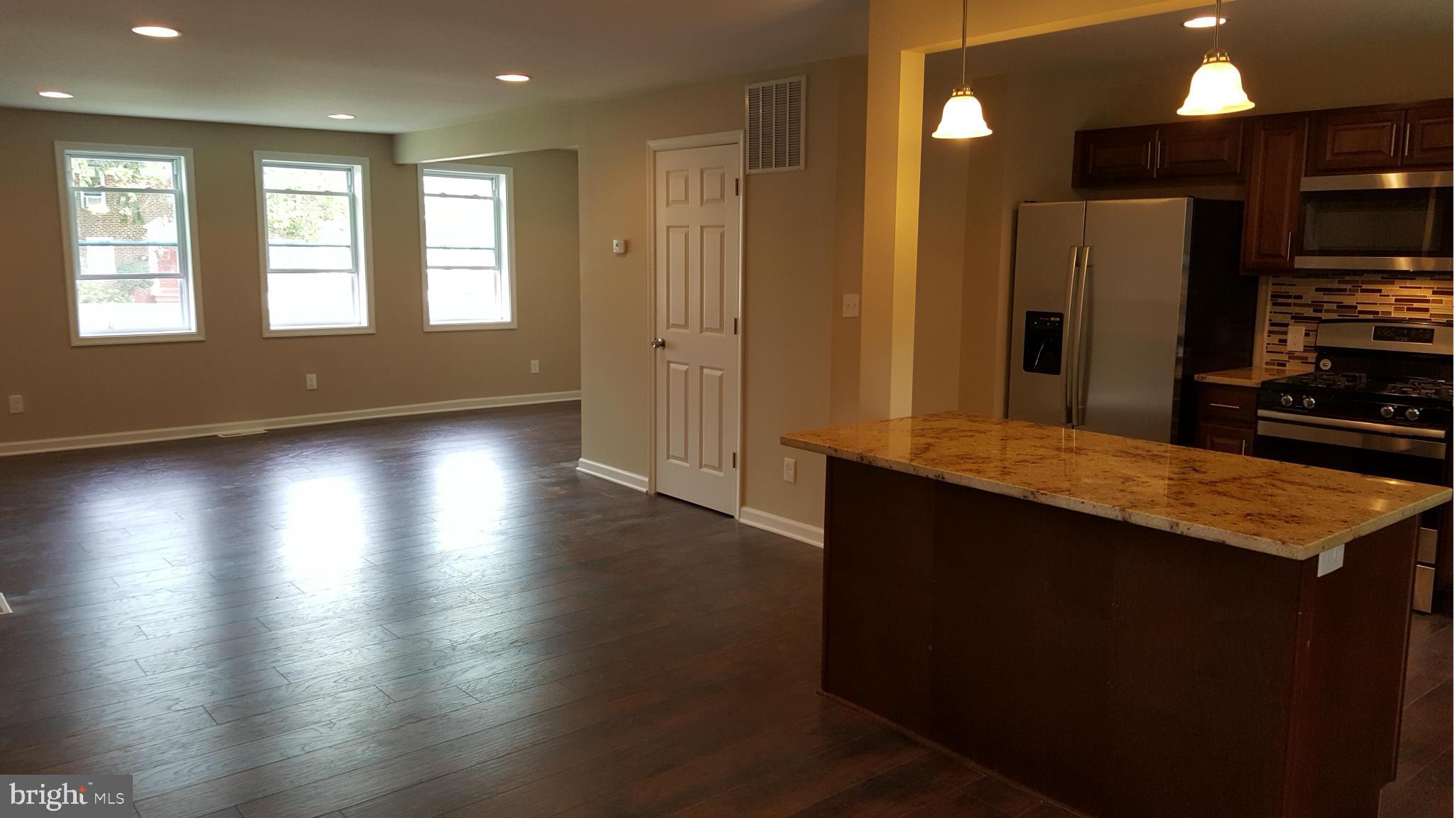 1645 Northgate Road Baltimore, MD 21218 - Photo 16 of 23 a kitchen with stainless steel appliances wooden floors and wooden cabinets
