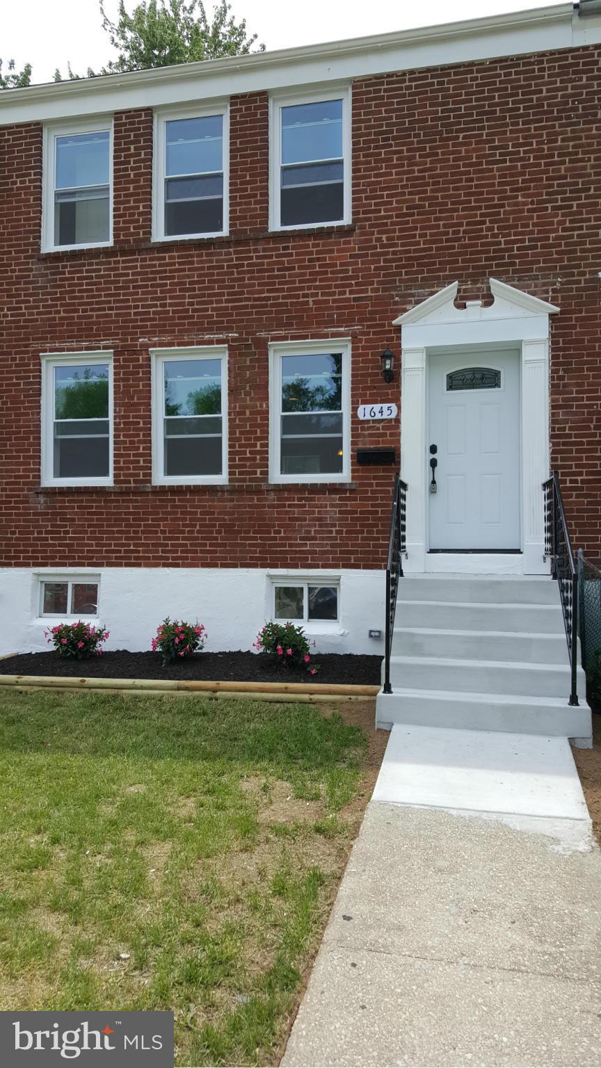 1645 Northgate Road Baltimore, MD 21218 - Photo 19 of 23 a front view of a house with a garden and yard