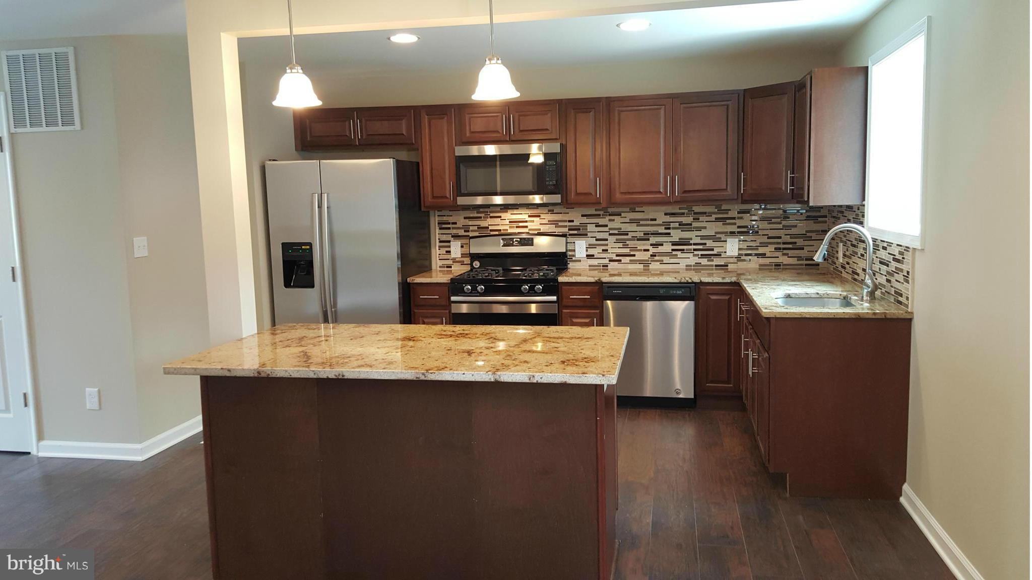 1645 Northgate Road Baltimore, MD 21218 - Photo 22 of 23 a kitchen with stainless steel appliances granite countertop wooden cabinets a refrigerator a sink and a stove