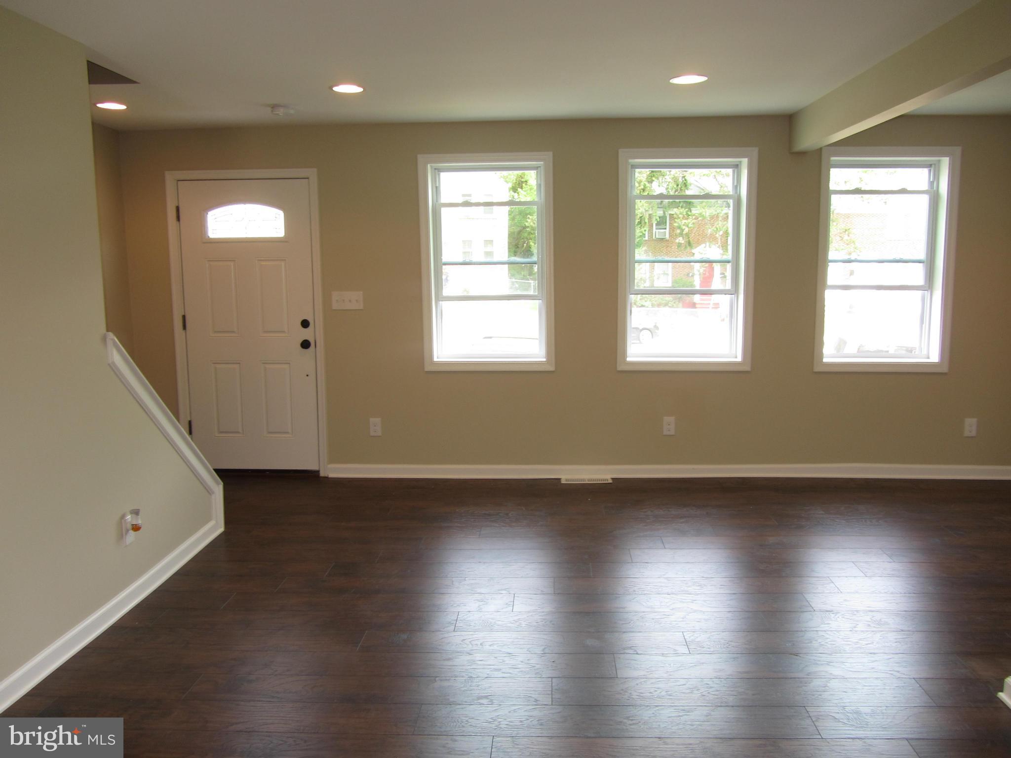 1645 Northgate Road Baltimore, MD 21218 - Photo 6 of 23 an empty room with wooden floor and windows