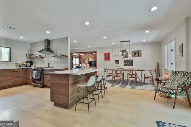 a kitchen with stainless steel appliances kitchen island granite countertop a sink and a refrigerator