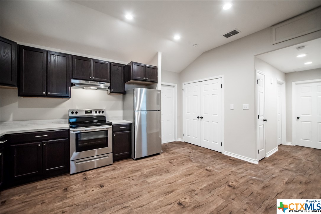 801-803 South Main Street Victoria, TX 77901 - Photo 5 of 11 a kitchen with refrigerator cabinets and wooden floor