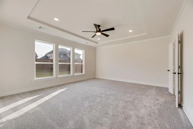 an empty room with windows and ceiling fan
