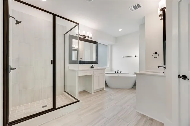 a bathroom with a double vanity sink mirror and bathtub