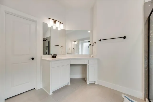 a bathroom with a sink mirror and a shower