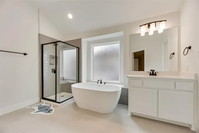 a spacious bathroom with a double vanity sink mirror and bathtub