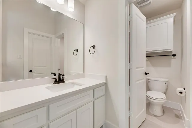 a bathroom with a sink a toilet and a large mirror