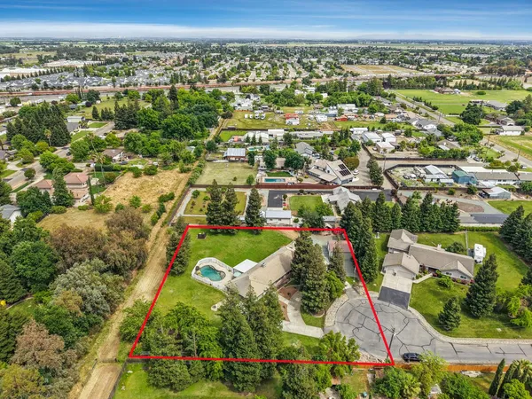 an aerial view of residential houses with outdoor space and trees