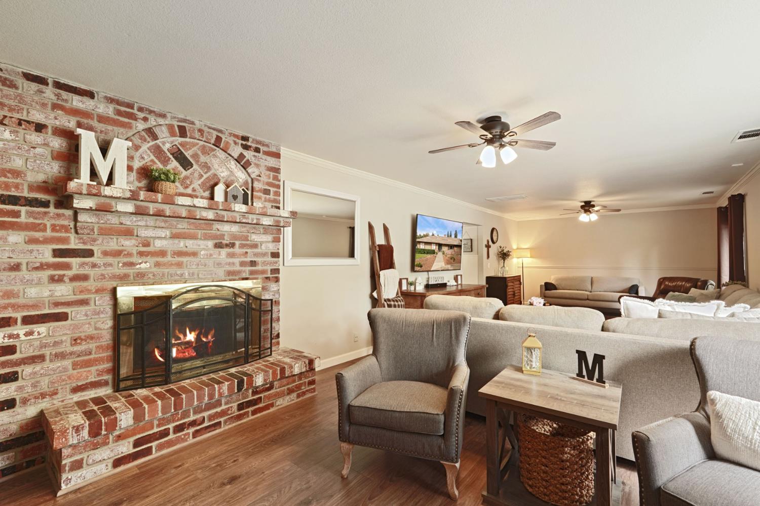 12963 Spring Time Lane Galt, CA 95632 - Photo 11 of 49 a living room with furniture a fireplace and a ceiling fan