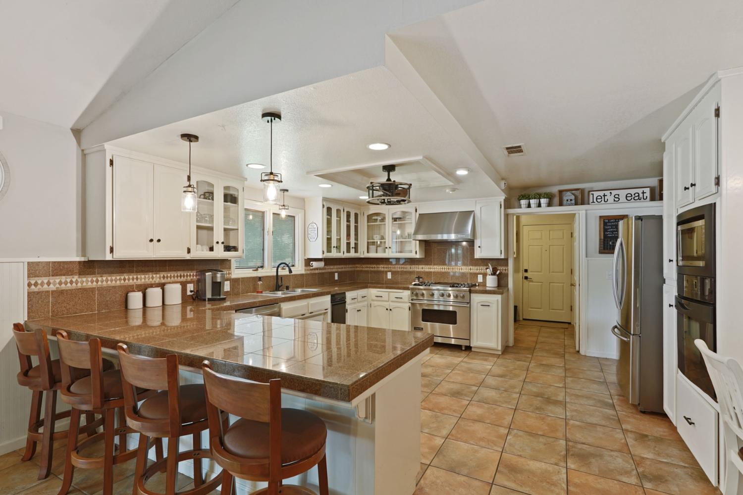12963 Spring Time Lane Galt, CA 95632 - Photo 15 of 49 a kitchen with stainless steel appliances granite countertop a stove refrigerator and cabinets