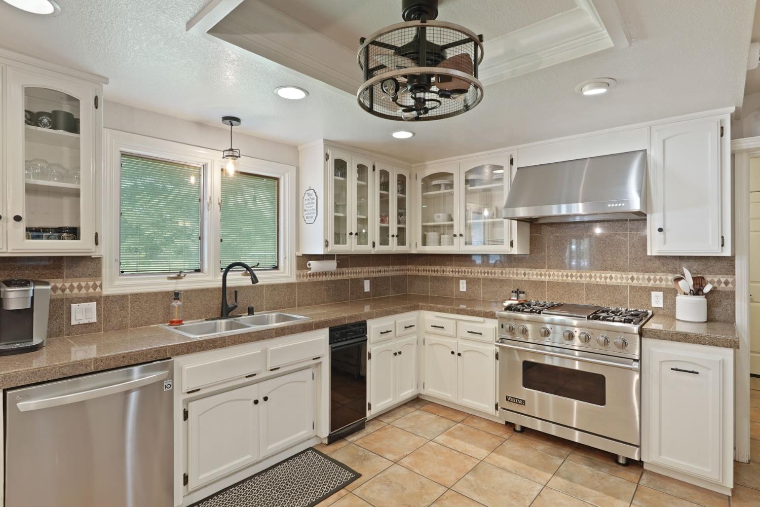 12963 Spring Time Lane Galt, CA 95632 - Photo 17 of 49 a kitchen with a sink stainless steel appliances cabinets and a window
