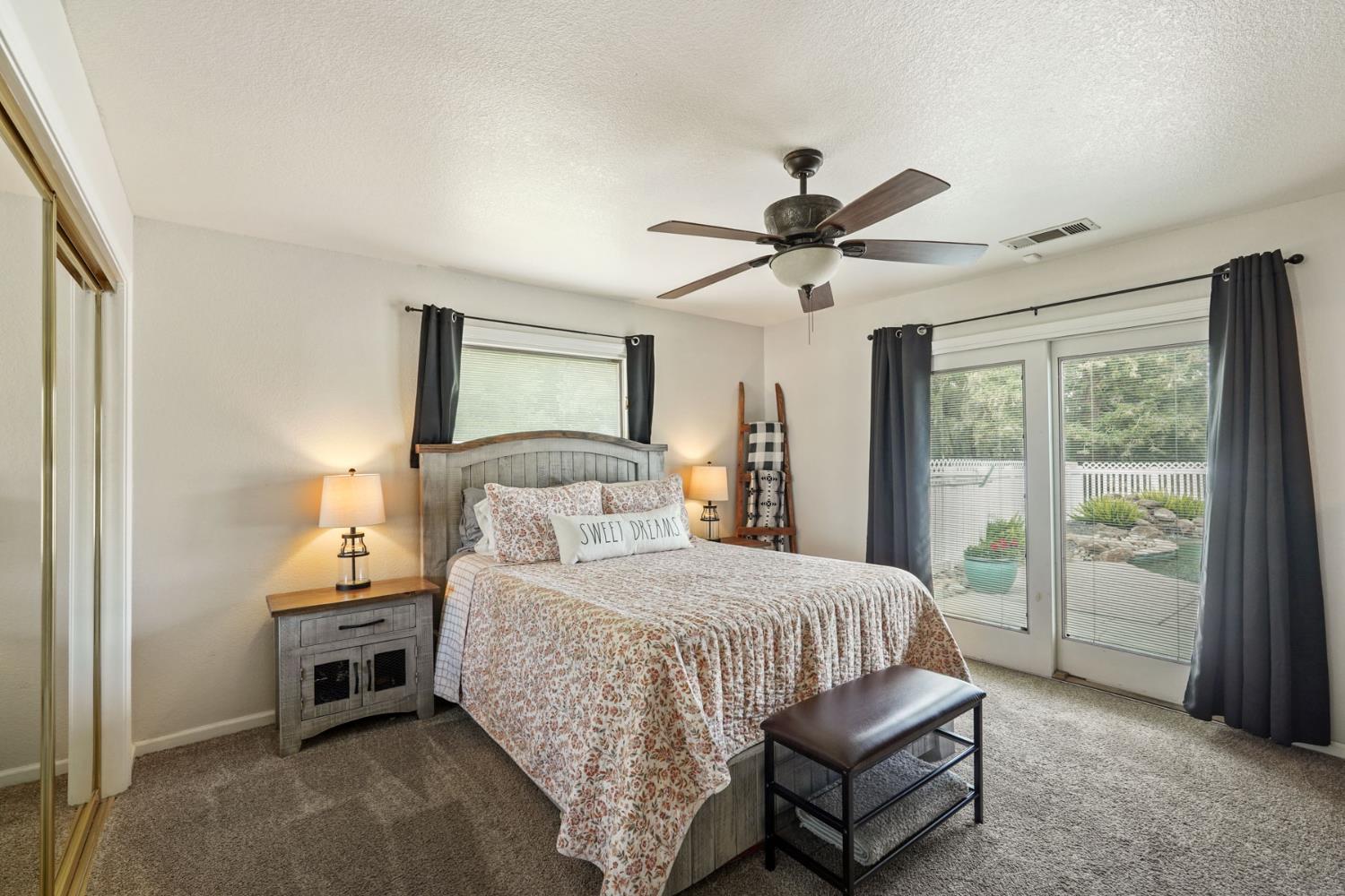 12963 Spring Time Lane Galt, CA 95632 - Photo 30 of 49 a bedroom with a bed and a chandelier