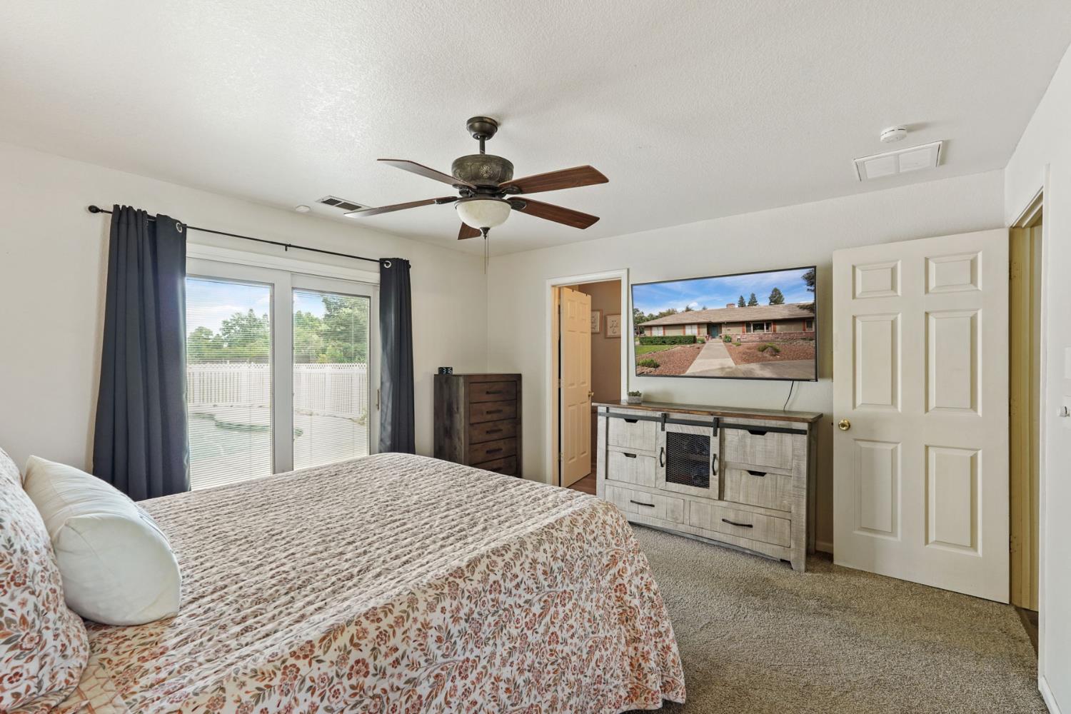 12963 Spring Time Lane Galt, CA 95632 - Photo 32 of 49 a bedroom with a large bed and a chandelier
