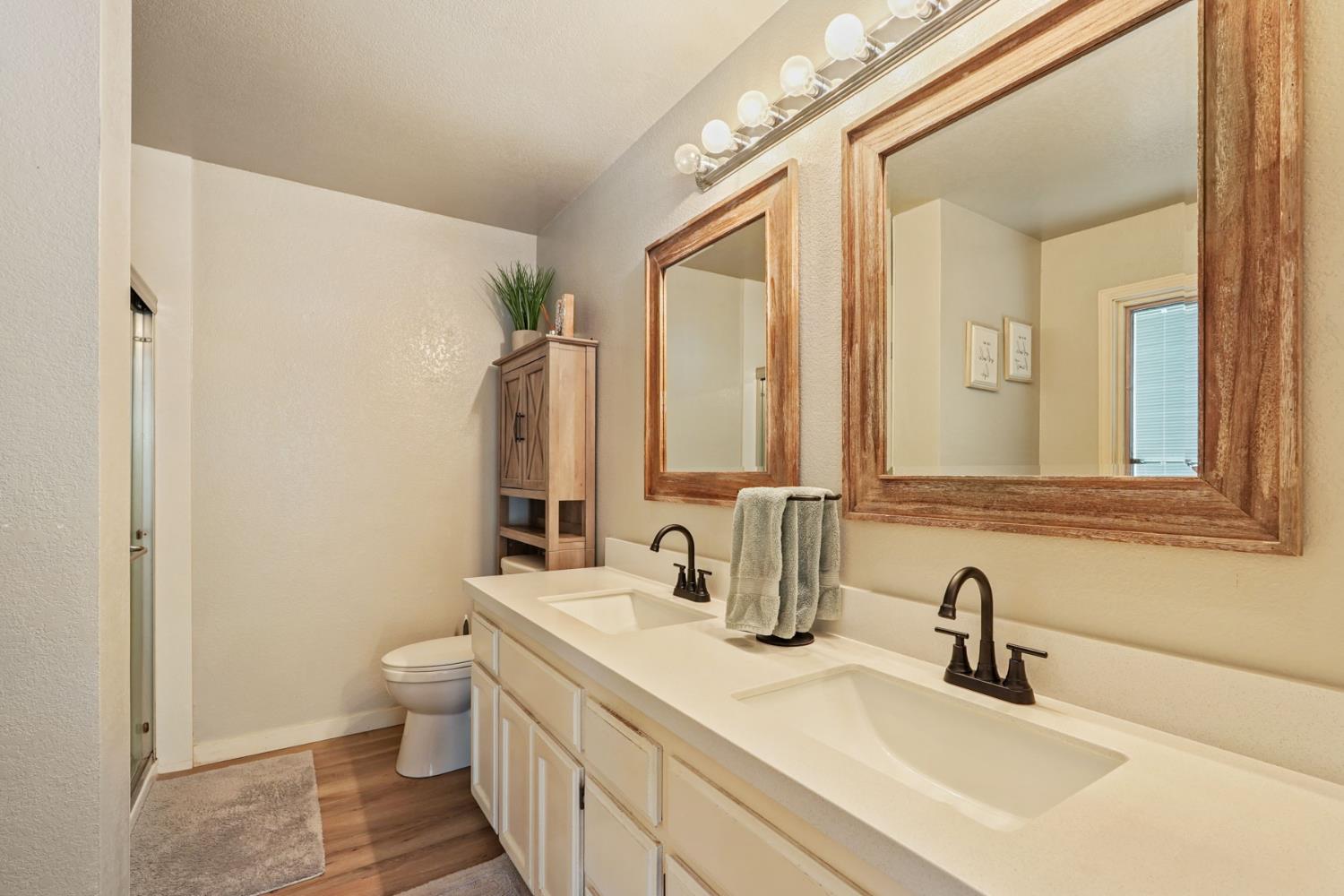 12963 Spring Time Lane Galt, CA 95632 - Photo 33 of 49 a bathroom with double vanity sinks a mirror and a shower
