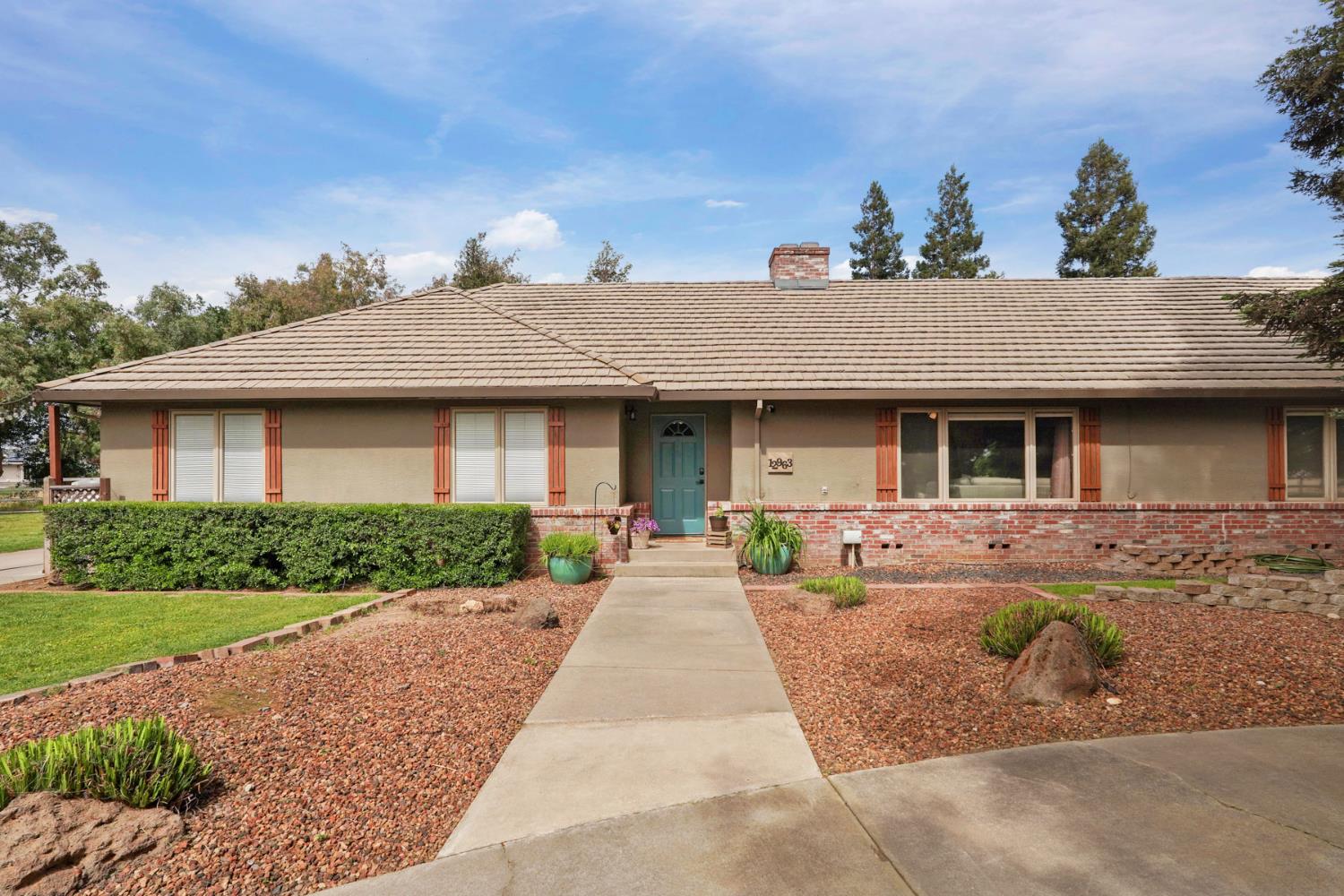 12963 Spring Time Lane Galt, CA 95632 - Photo 8 of 49 a front view of a house with a yard and potted plants