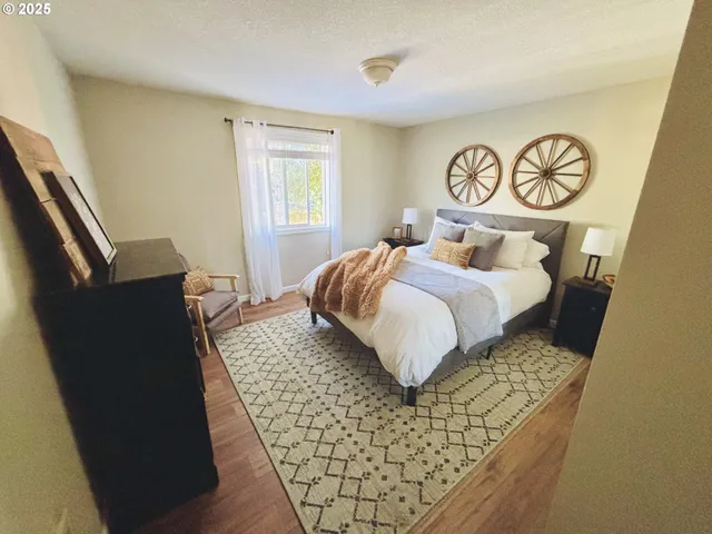 a bedroom with a bed and painting on the wall