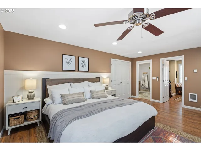 a bedroom with a large bed and ceiling fan