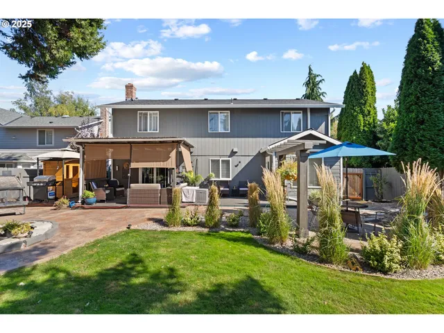a view of a house with table and chairs under an umbrella
