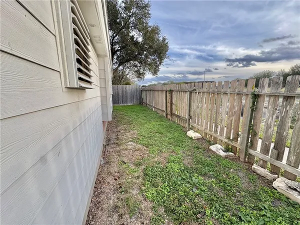 a view of a yard with wooden fence