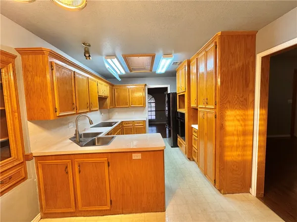 a kitchen with stainless steel appliances granite countertop a refrigerator a sink dishwasher and a stove with wooden floor