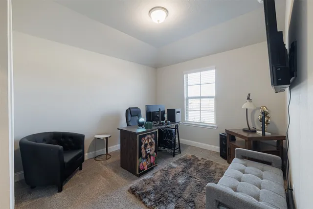 a living room with furniture a flat screen tv and a window