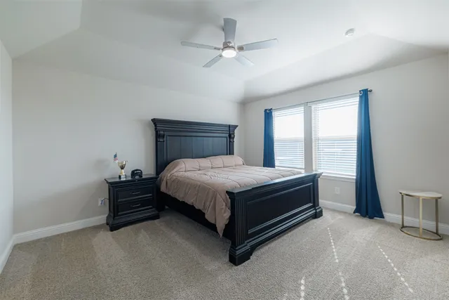 a bed sitting in a spacious bedroom next to a window