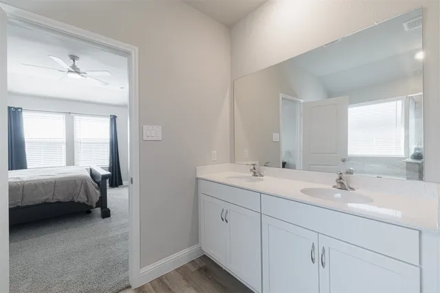a en suite bathroom with a double vanity sink and a mirror