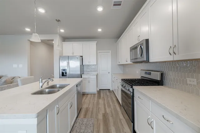 a kitchen with stainless steel appliances granite countertop a sink stove and refrigerator