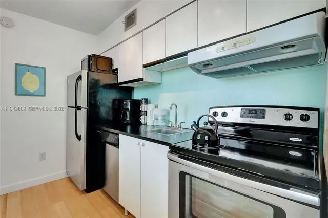 a kitchen with stainless steel appliances granite countertop a refrigerator and a stove