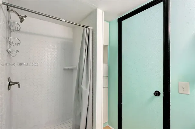 a bathroom with a shower and a glass door