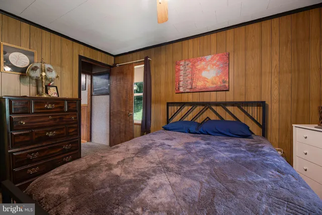 a hallway with chandelier and wooden floor