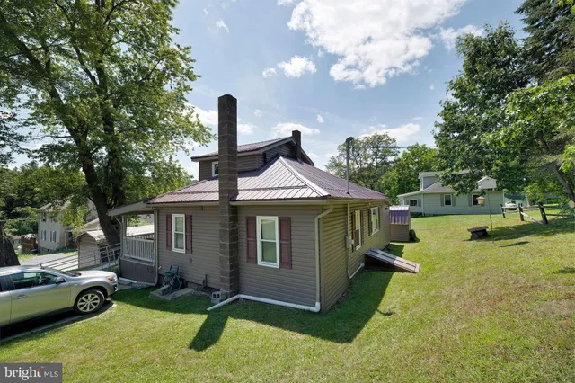 a view of a house with a yard patio and a slide