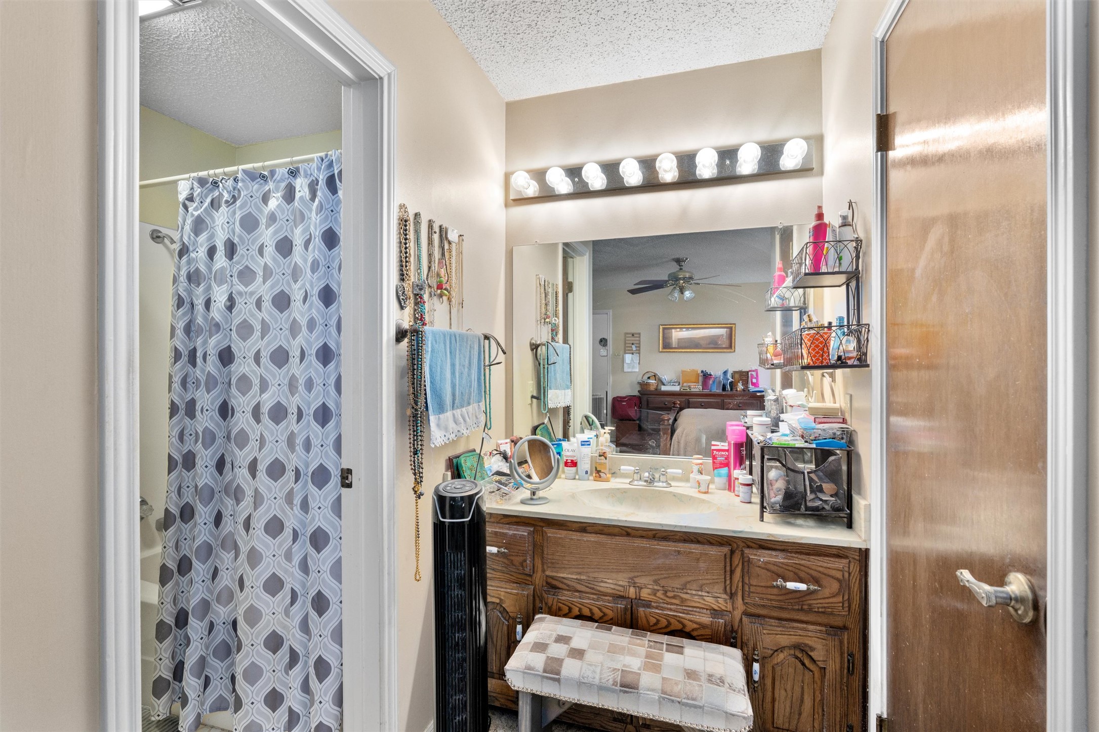 401 Drake Lane Taylor, TX 76574 - Photo 16 of 31 Bathroom vanity with integrated sink, wood-finish cabinetry, and a full-width mirror