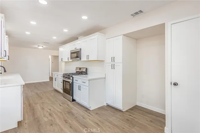 a kitchen with a refrigerator a stove top oven a sink and dishwasher
